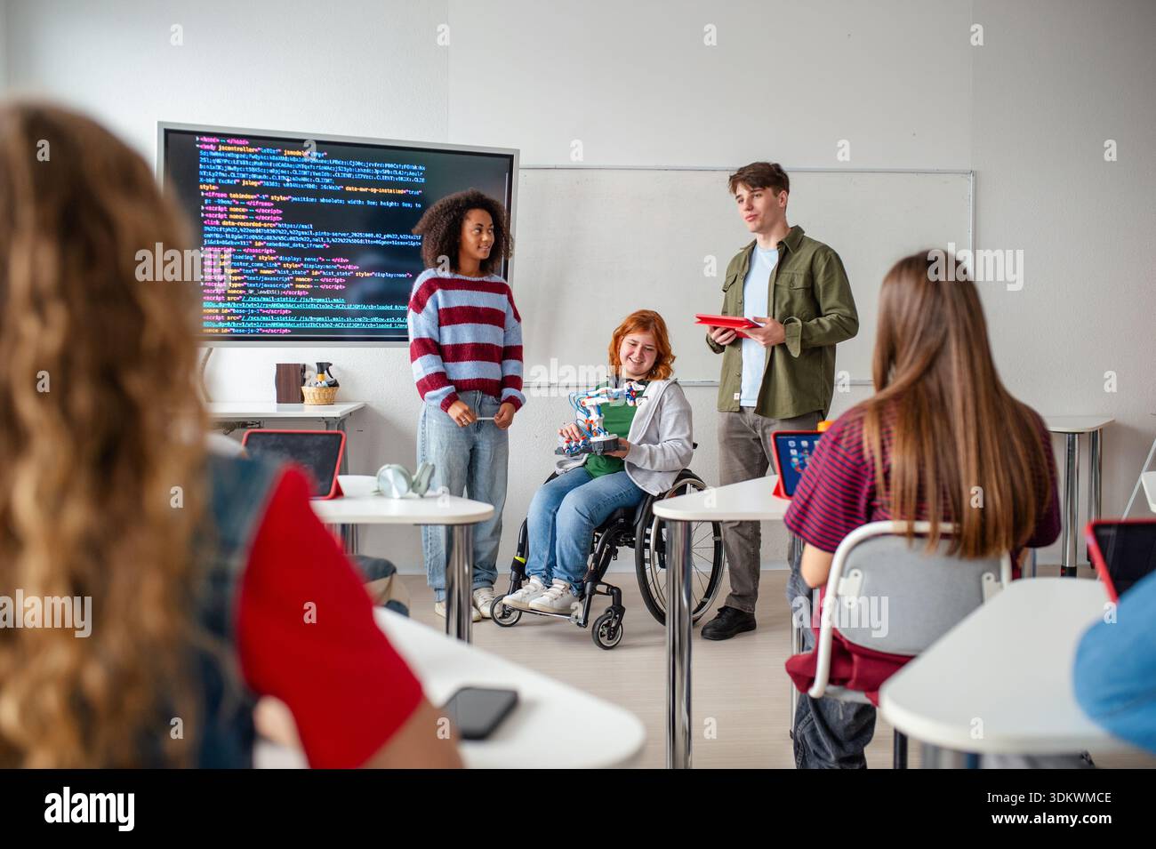 Inclusive student team presenting technology project in class. Stock Photo