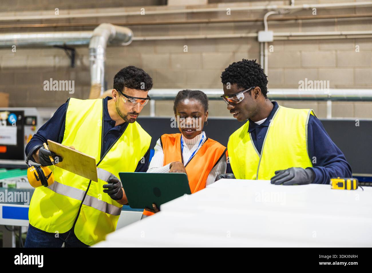 Diverse industrial workers collaborating on a project controlling production Stock Photo