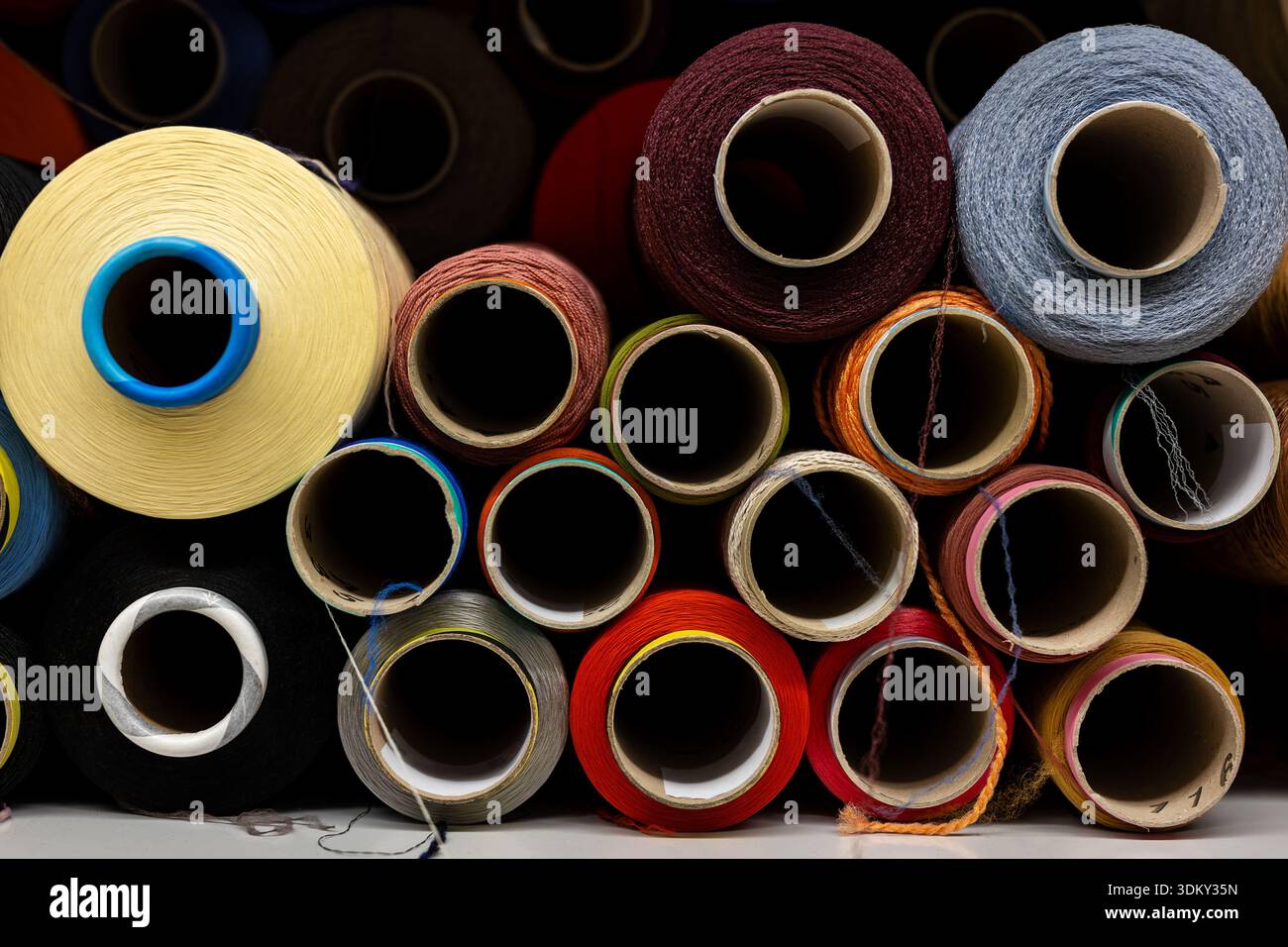 Visible Plot Thread Colorful textile thread spools stacked warehouse show fiber production ...