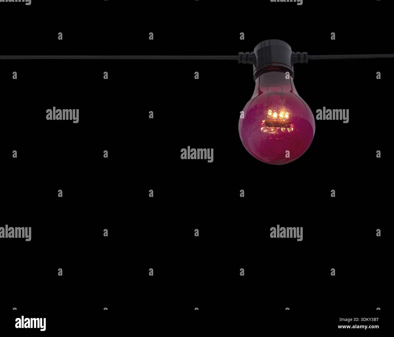 Red color lightbulb on string isolated on black Stock Photo