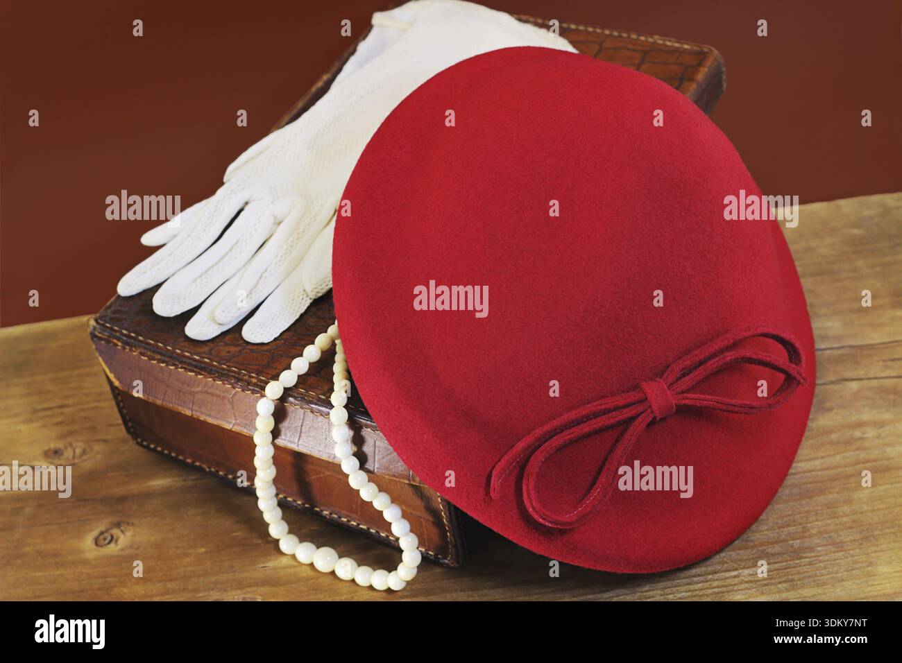 Red hat, white gloves and bone beads on leather case Stock Photo