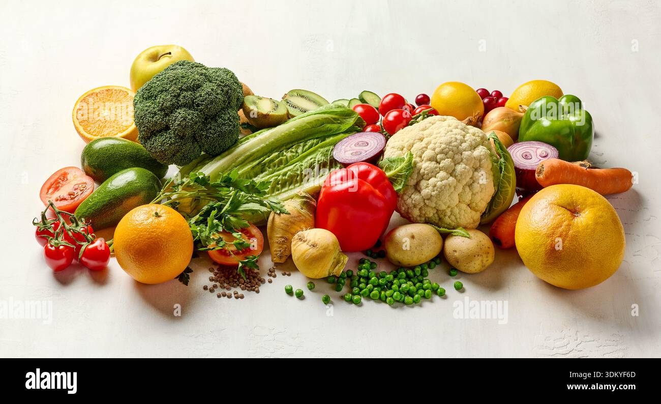 various fresh raw vegetables and fruits on white table Stock Photo
