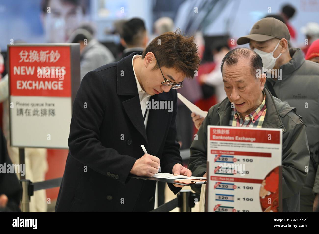 A staff assisting a man for exchang the new bank note for Lunar New ...