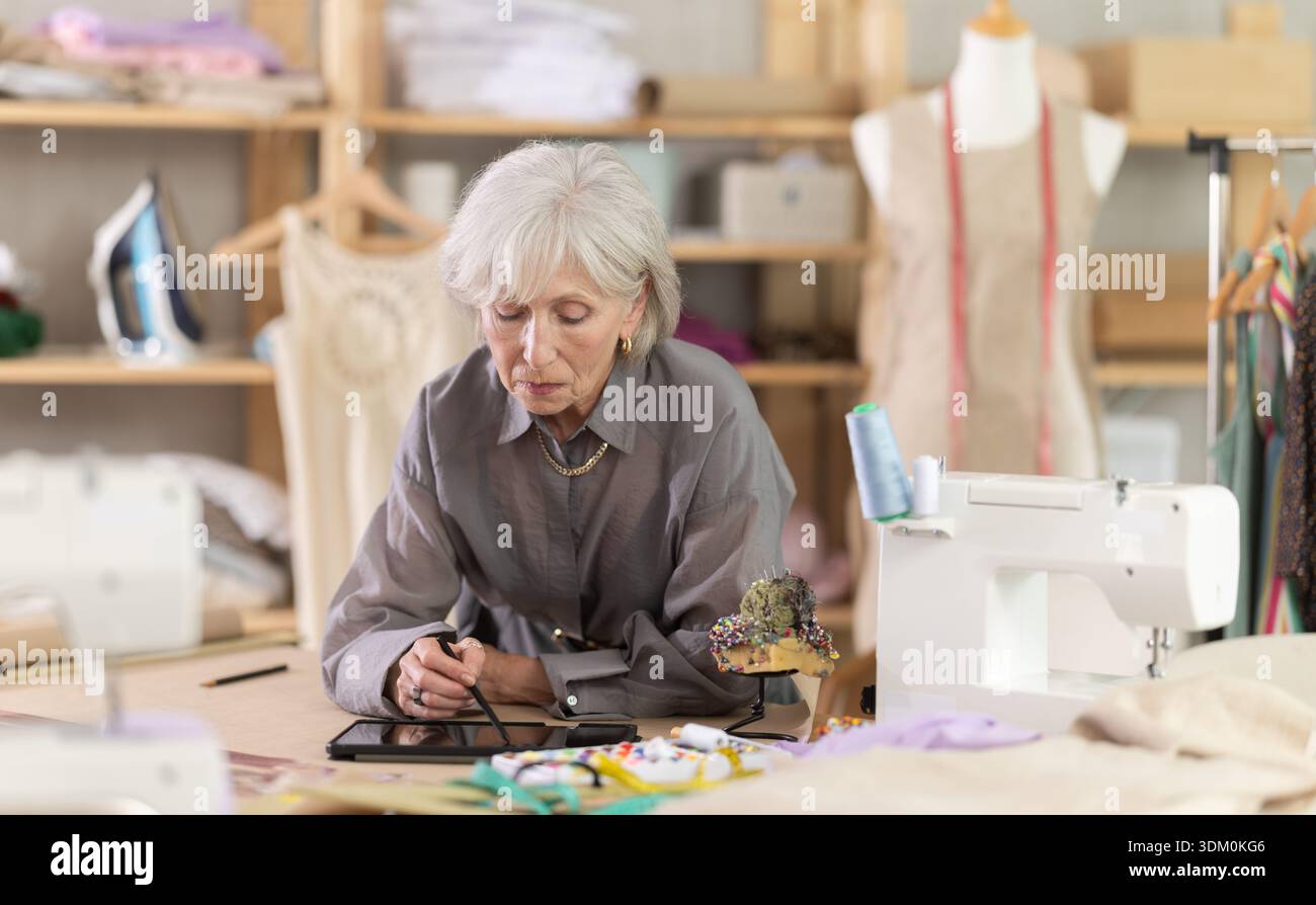 Woman dressmaker makes pattern using tablet Stock Photo
