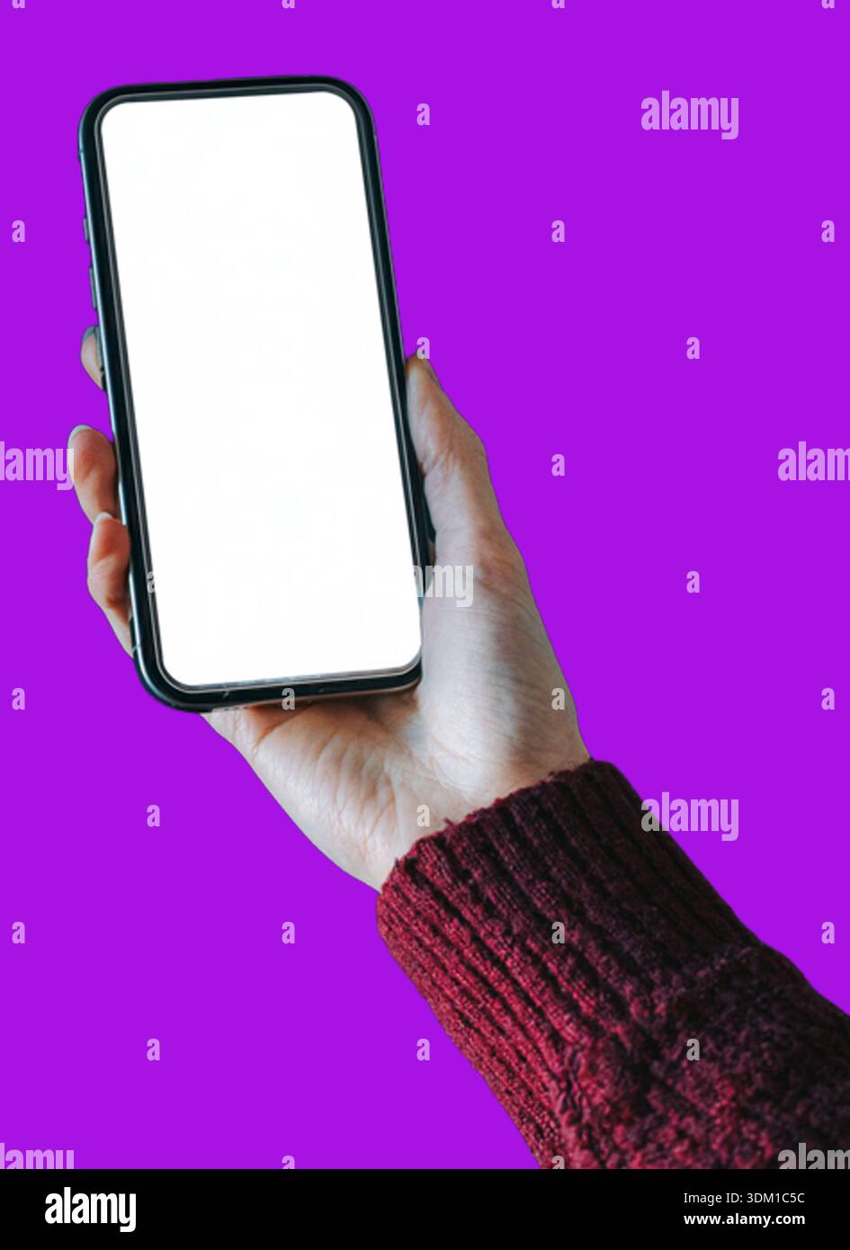 A hand holding a modern smartphone with a blank white screen against a ...