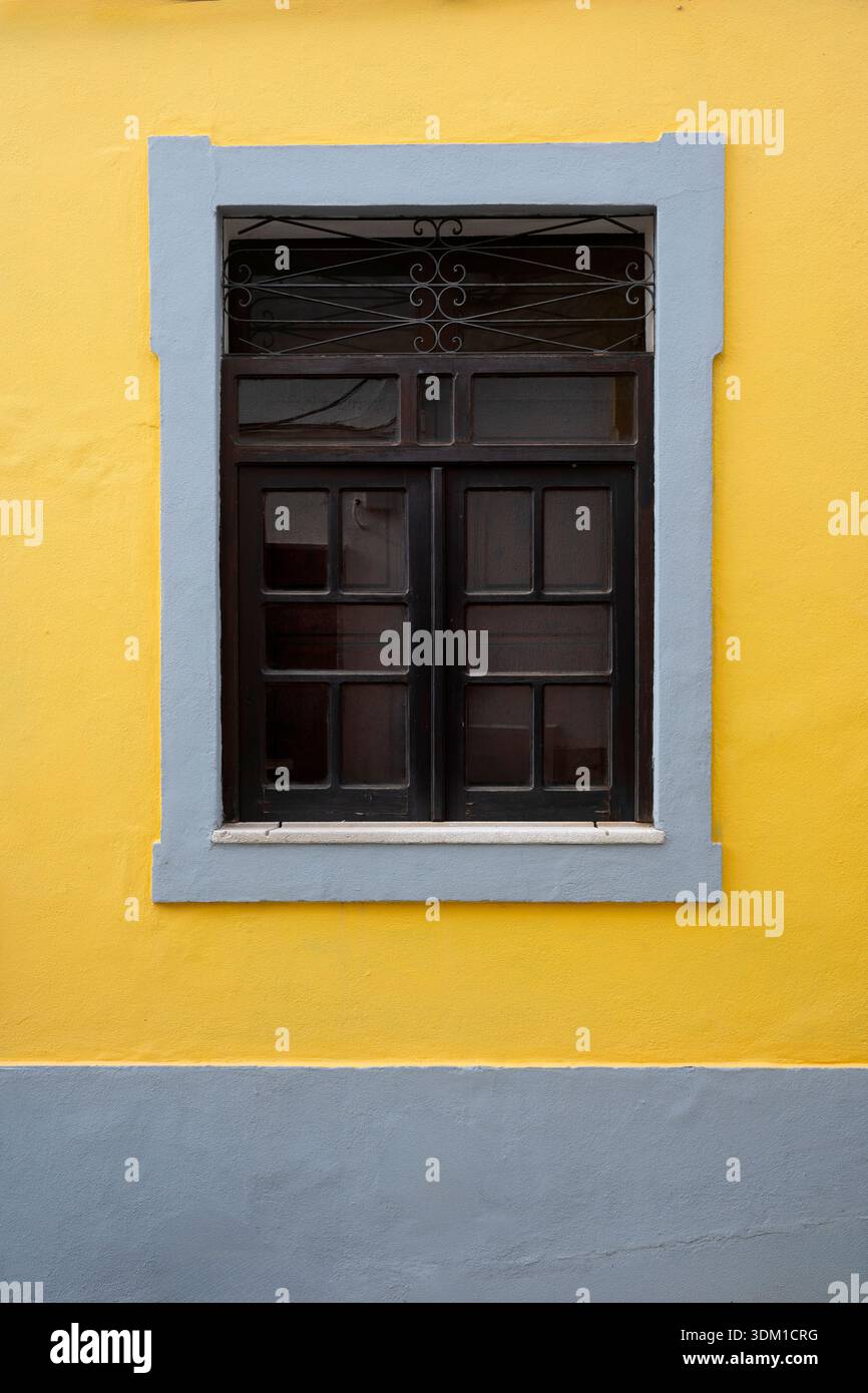 Bright yellow wall with grey window frame Stock Photo