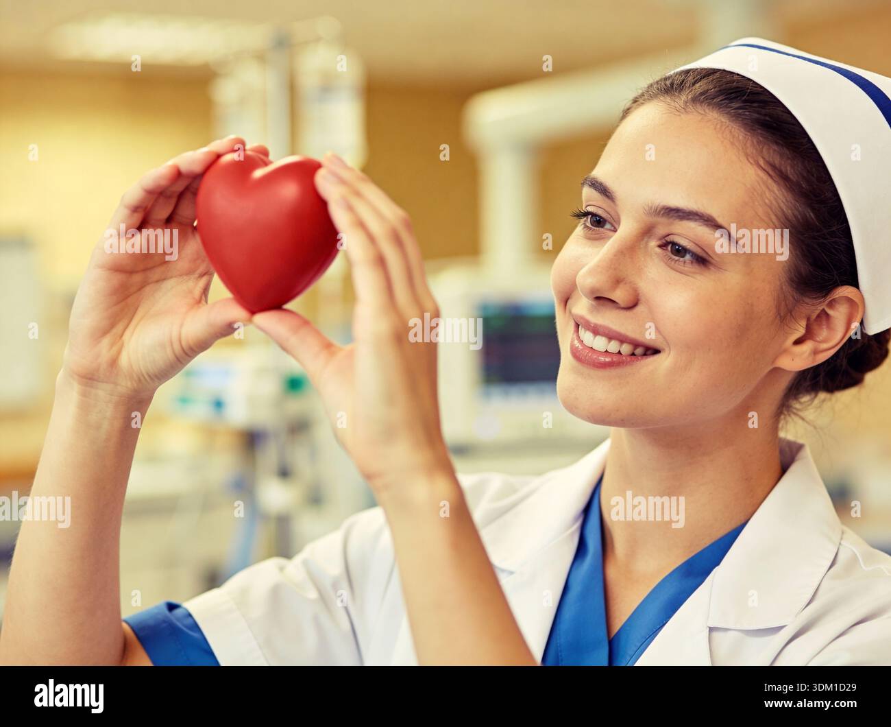 A nurse is holding a heart in her hand and smiling. Concept of warmth ...