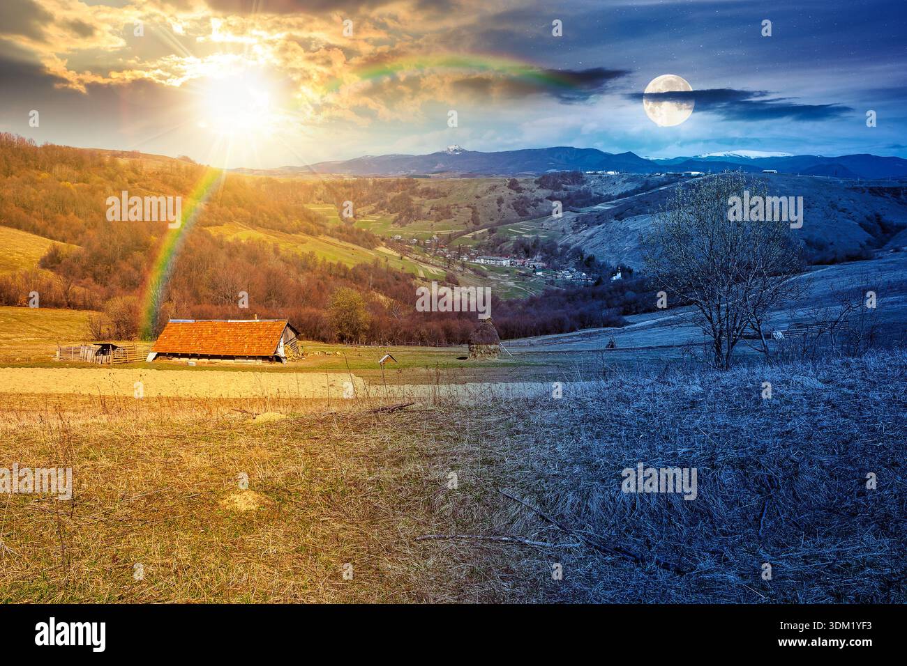 rural landscape with village in valley. day and night time change concept. outdoor adventure in countryside with rolling hill, snowy mountain under su Stock Photo