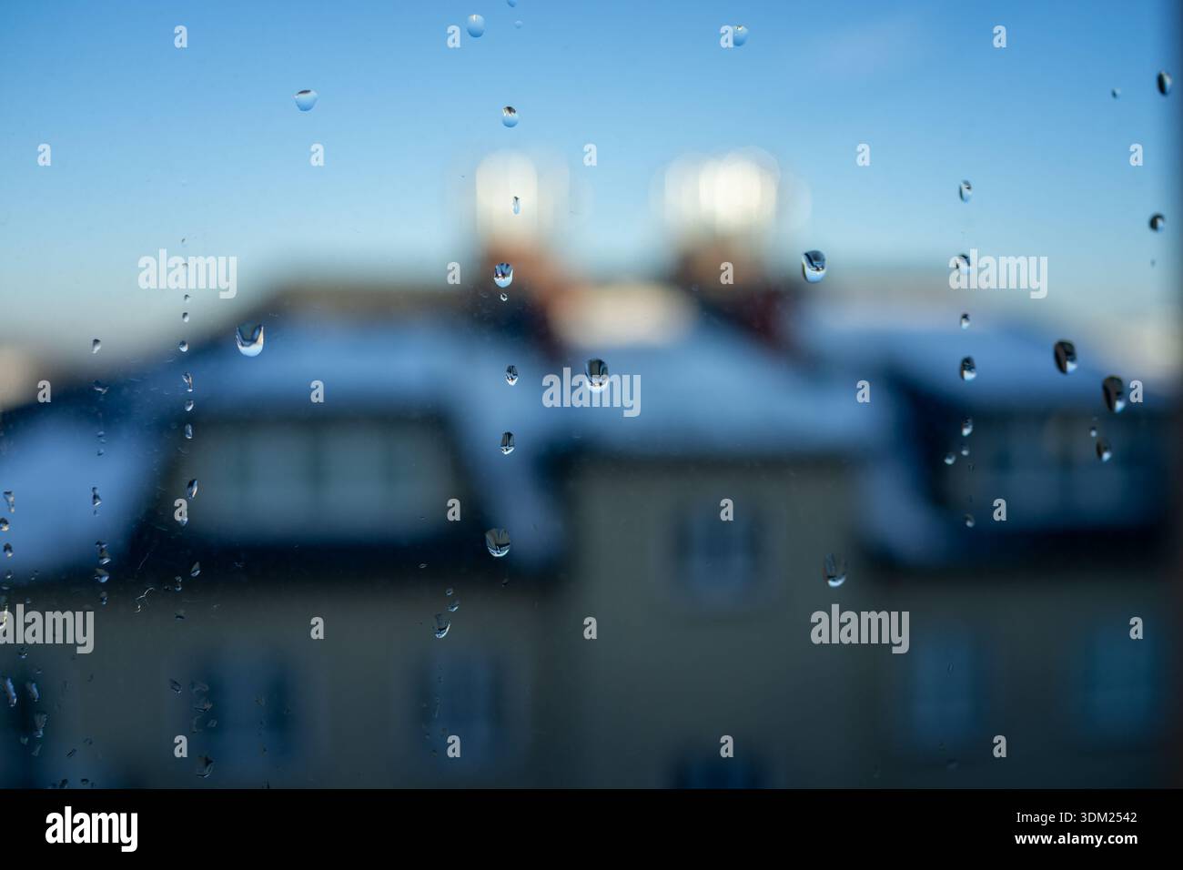 Close-up rain droplets on glass, blurred warm lights beyond, evoking intimate rainy night closeness