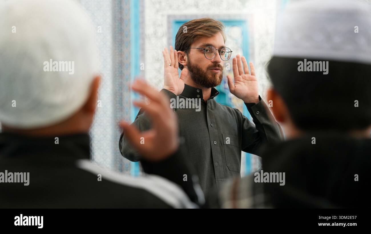 Muslim Sheikh teaching kids how to pray in a mosque. Ramadan Quran ...