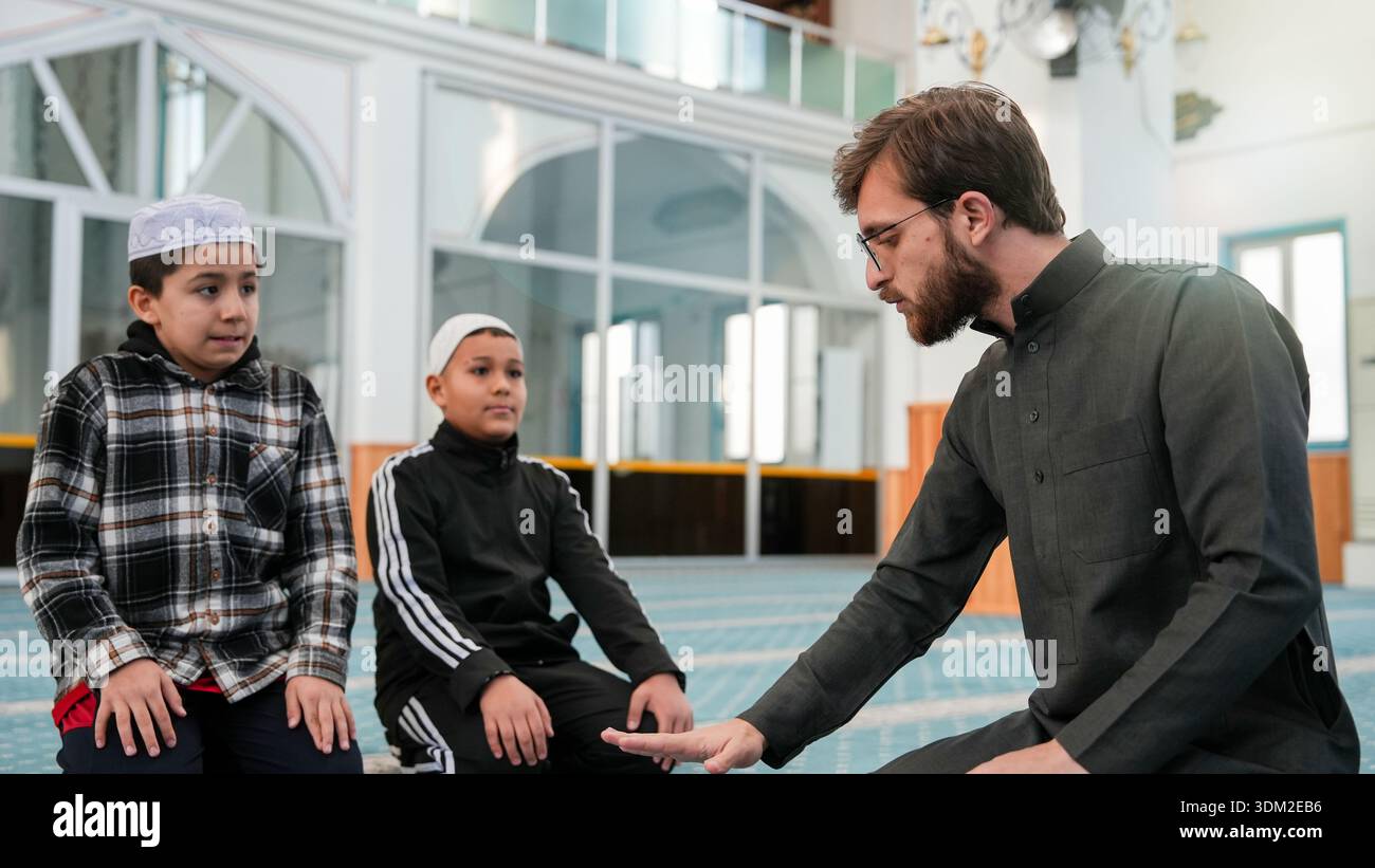 Muslim Sheikh teaching kids how to pray in a mosque. Ramadan Quran ...
