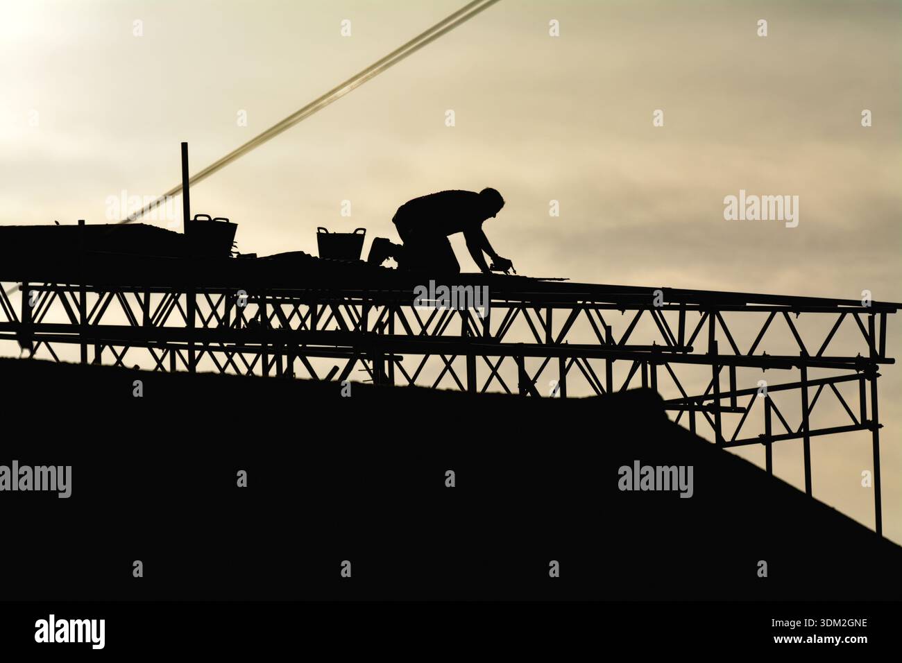 A builder working on scaffolding on a private house about to undergo renovation to a extension to the property Stock Photo