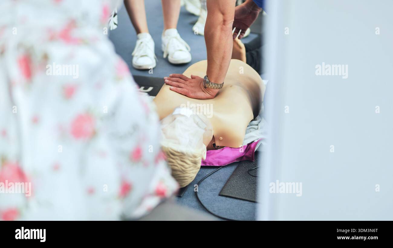 CPR training session showing person performing chest compressions on a ...