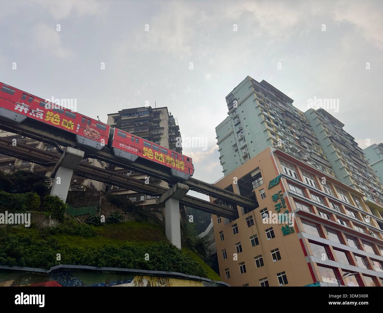Chongqing, China - Dec 6, 2023.Liziba station monorail train passing through residential buildings in Chongqing China - Smartphone Captured Stock Image