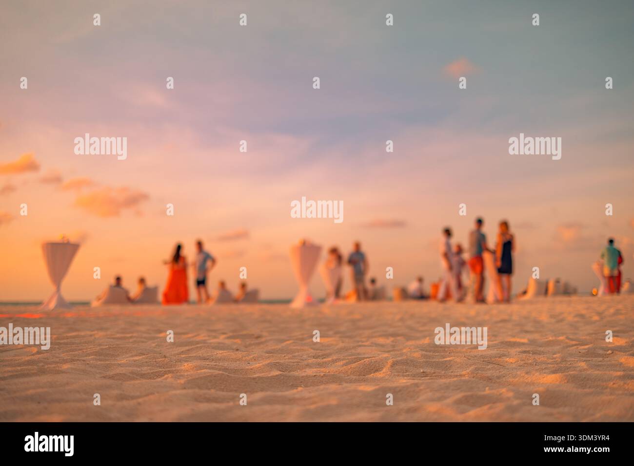 Blurred sunset beach party people background. Defocused beachfront holiday relax tropical ocean summer social scene copy space Stock Photo