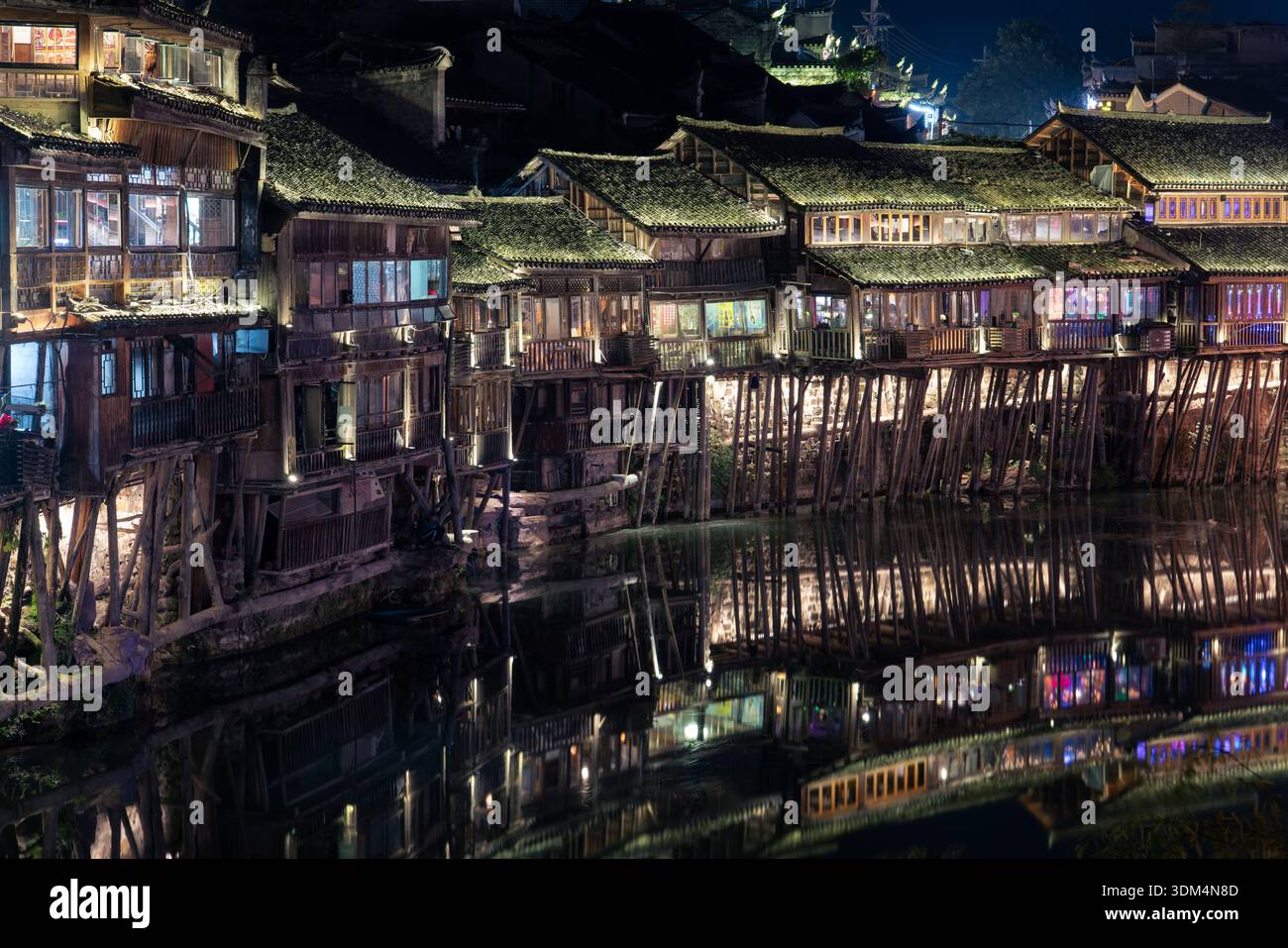 This is a night view of traditional Chinese houses along the riverside ...