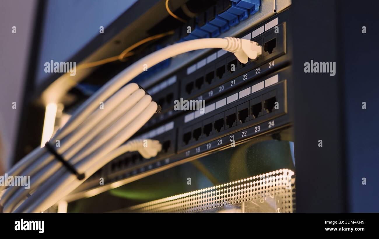 Ethernet cables connecting to a network switch in a data center rack Stock Photo