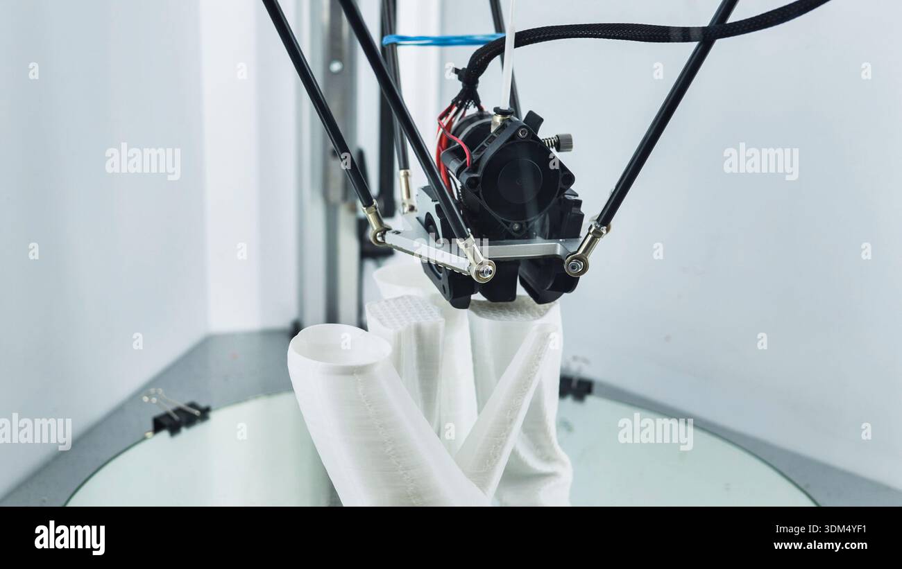 3D printer creating a white plastic prototype on a build platform Stock Photo