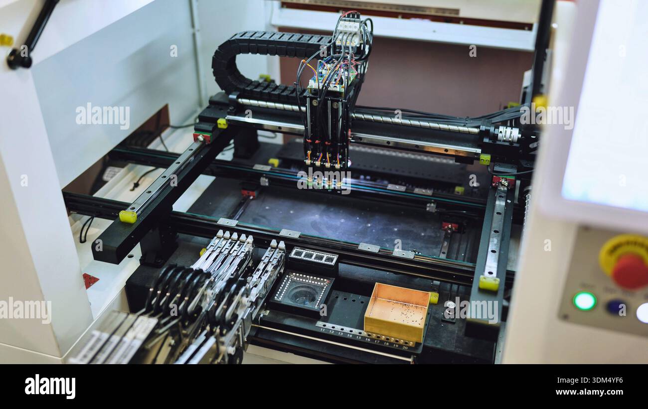 Pick and place machine assembling electronic components in SMT manufacturing facility Stock Photo