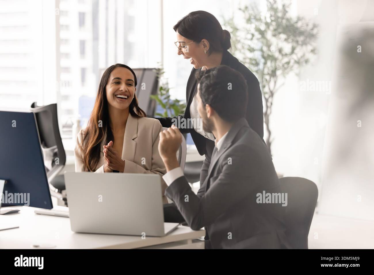 Three diverse laughing team members having fun during teamwork Stock Photo