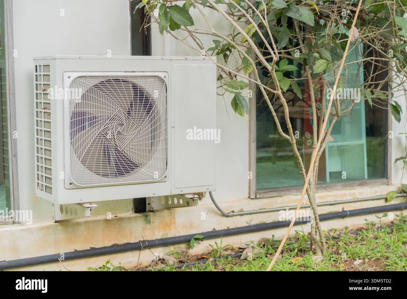 Dual inverter, combination of air conditioner compressor and heating pump, installed on a wall of family house. Stock Photo