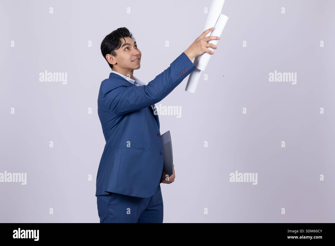 Architect in suit looking at building plan in studio Stock Photo