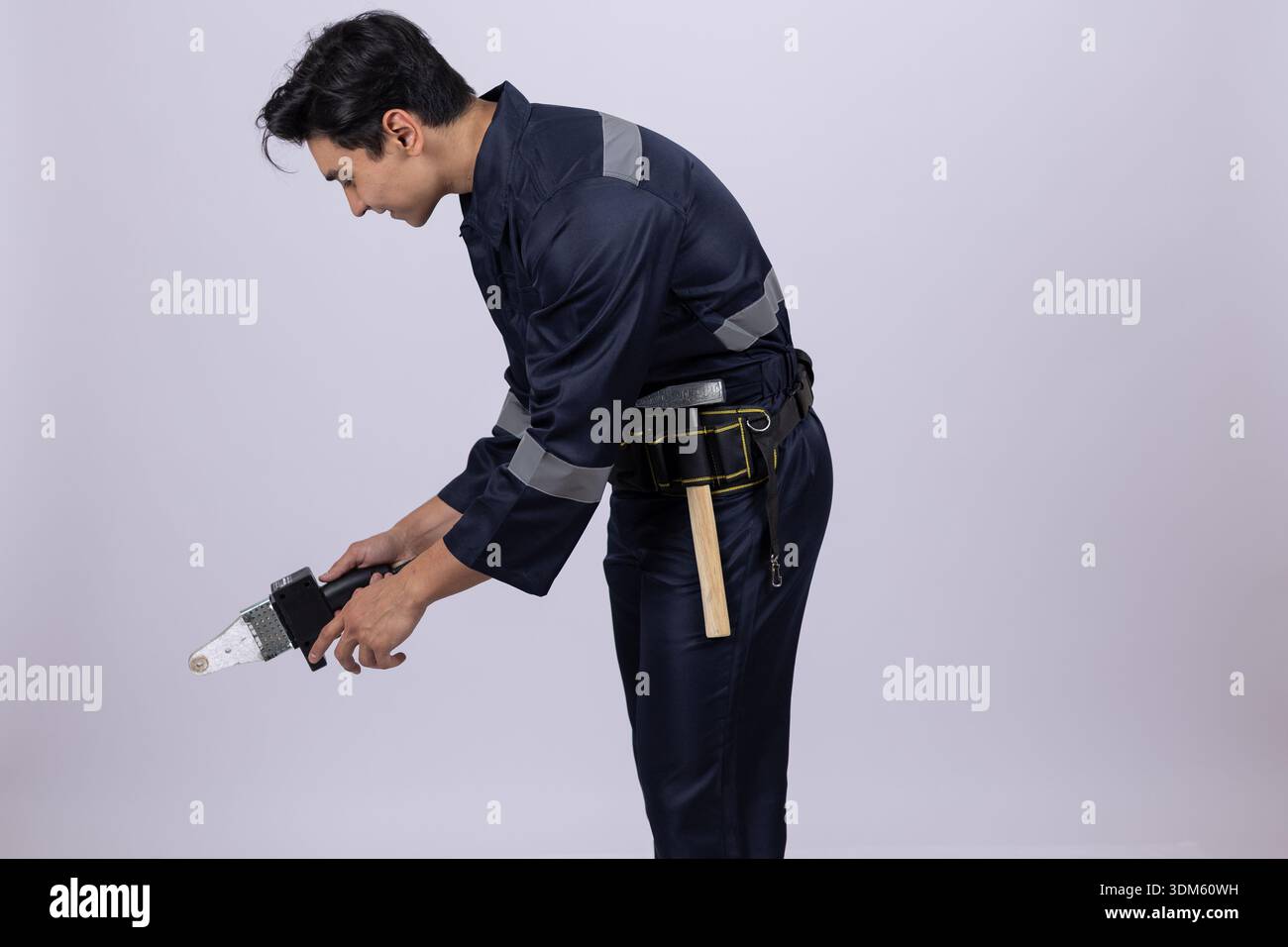 Electrician using screwdriver on floor in studio Stock Photo