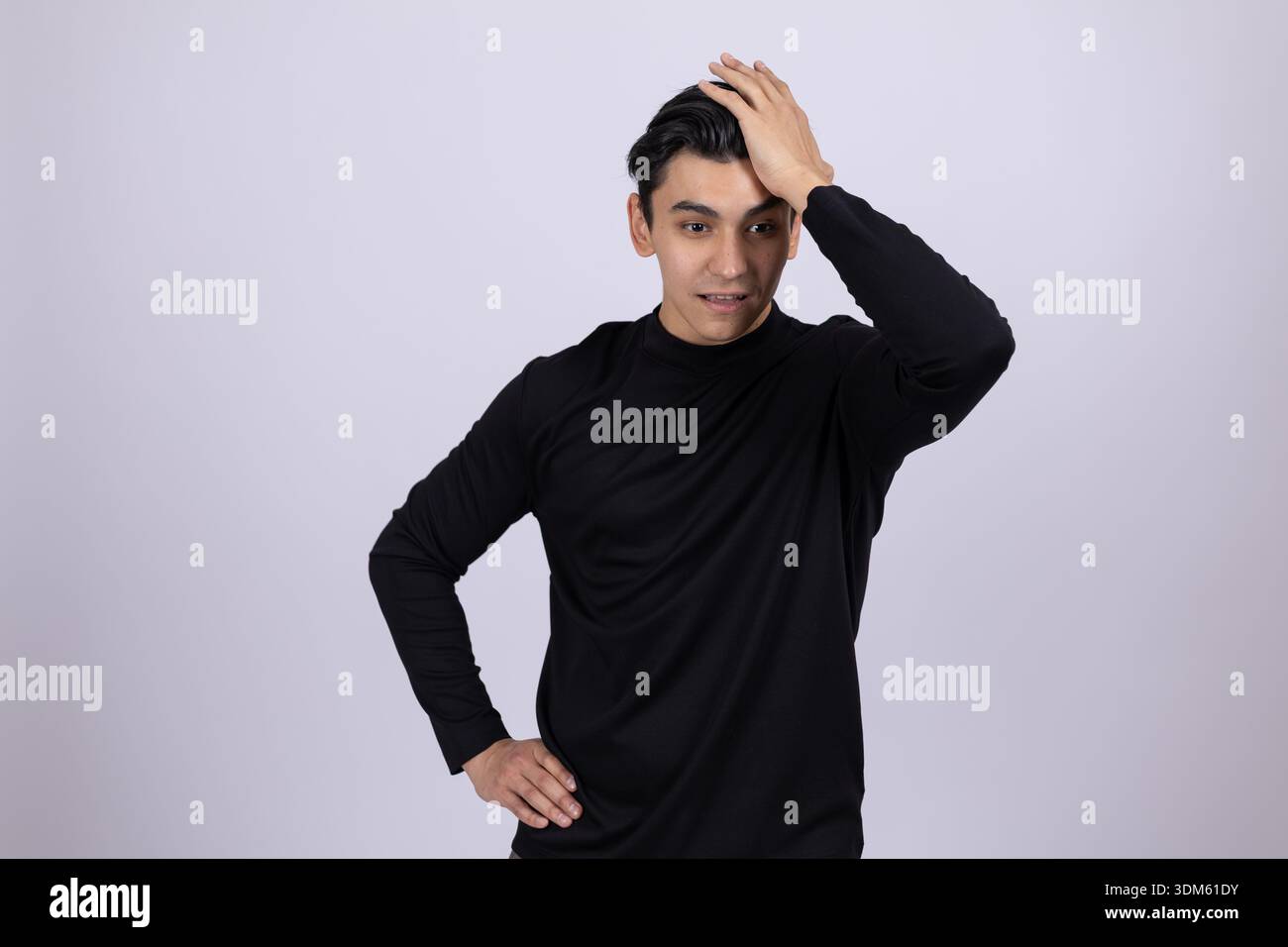 Man in black turtleneck touching his head in thought Stock Photo