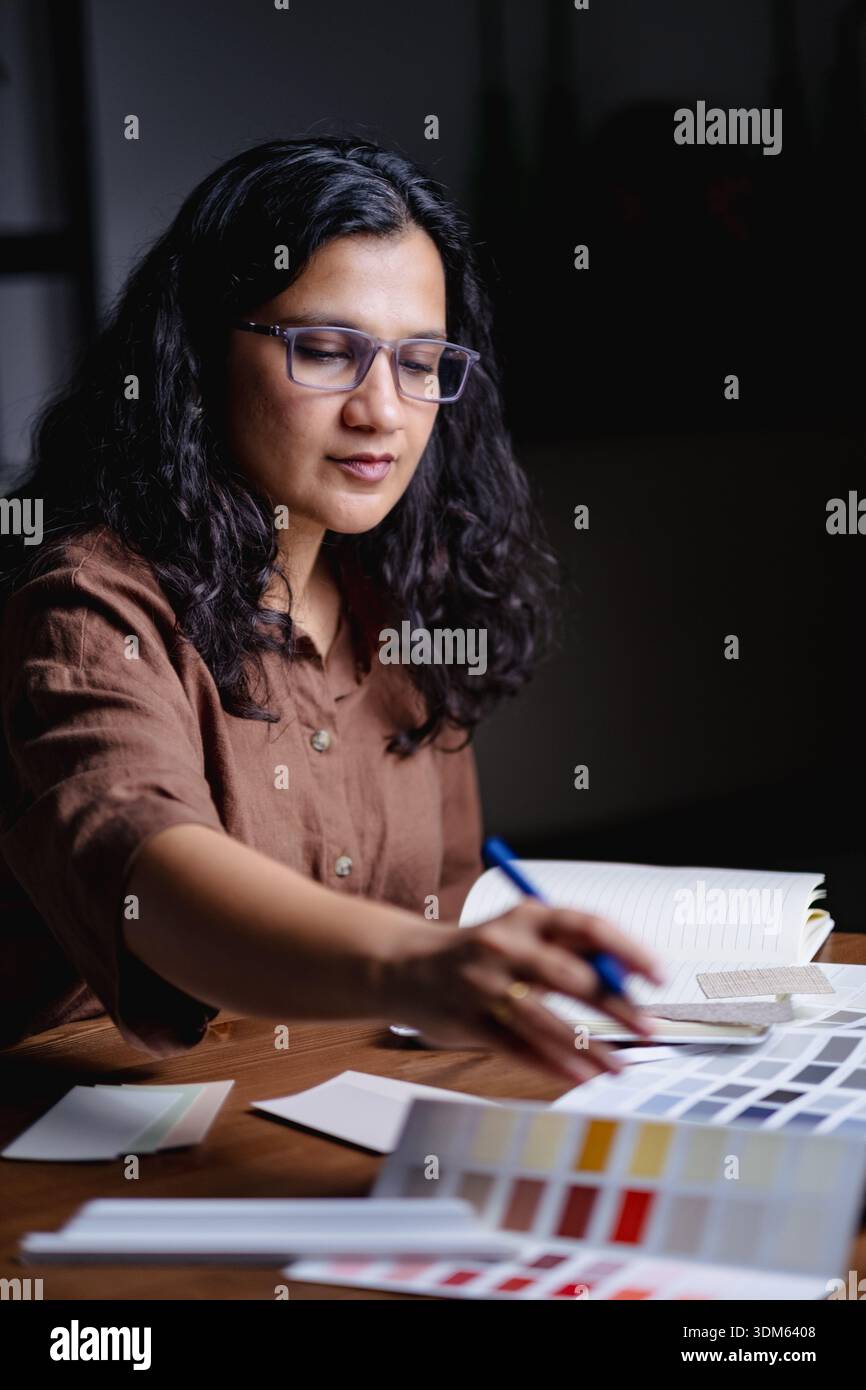 Interior designer working late night in studio with samples and materials Stock Photo