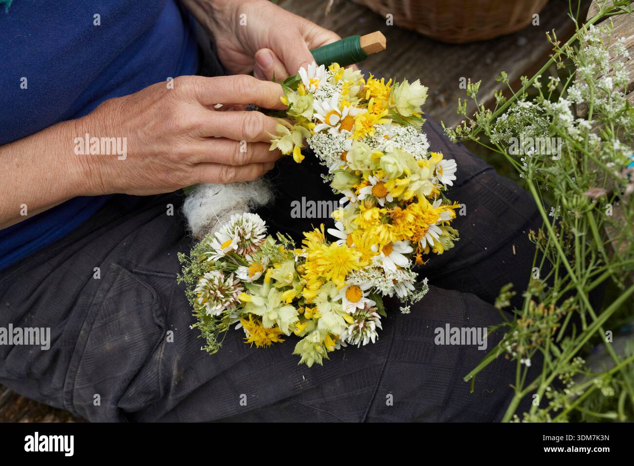 A woman binds a wreath on sheep's wool. Germany Stock Photo