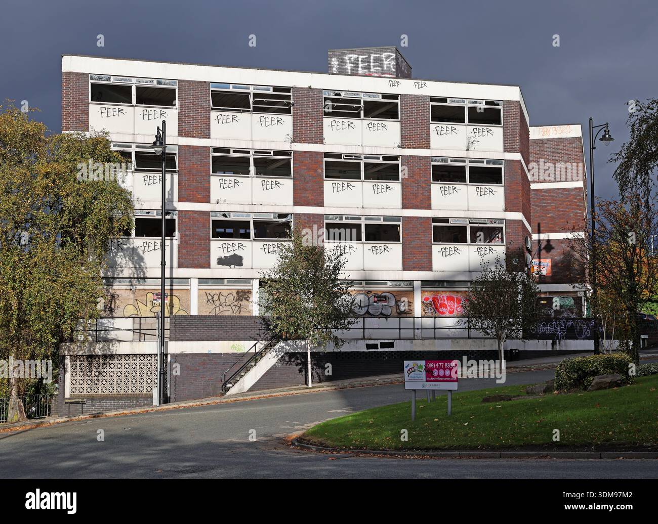 Vandalised and boarded-up Victoria House office building on Wellington Street, Stockport town centre, Manchester, England, UK, with FEER garaffiti Stock Photo
