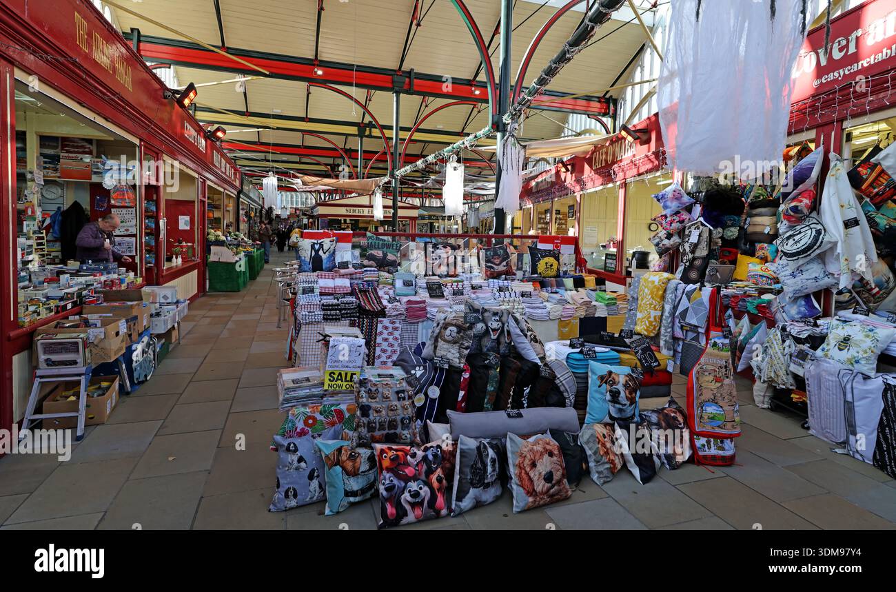 Interior of Stockport Market Hall with busy stalls selling textiles and household goods along the main aisle, Stockport, Greater Manchester, England Stock Photo