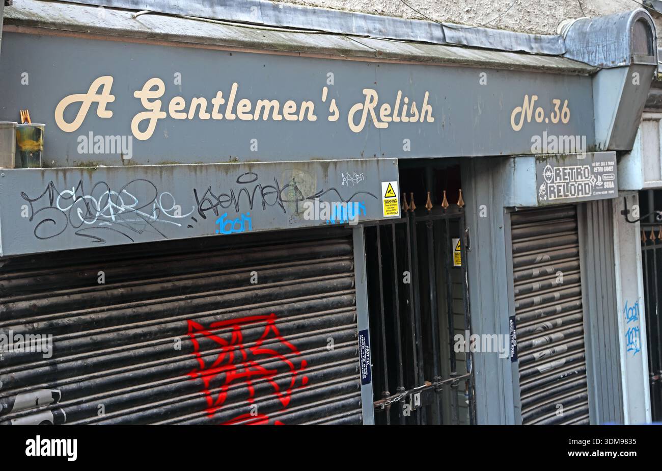 Shuttered and graffiti-marked shopfront of “A Gentlemen’s Relish” at 36 Bridge Street, Stockport town centre, Greater Manchester, England, UK. Stock Photo