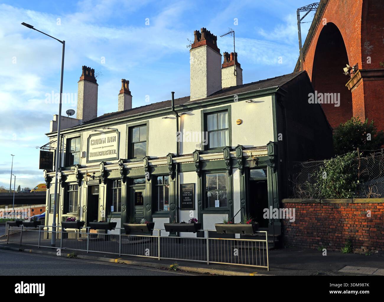 CAMRA listed Crown Inn pub on Heaton Lane, Stockport, beneath the brick railway viaduct, with “Crown Inn” and “Boddingtons Beer” signage visible Stock Photo