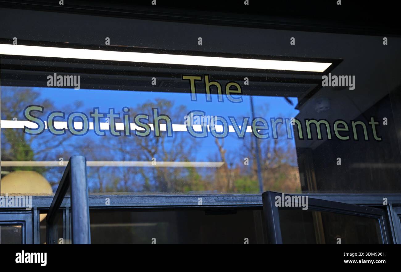 Entrance doors with “The Scottish Government” lettering on glass at St Andrew’s House, Regent Road, Edinburgh, Scotland, UK. Stock Photo