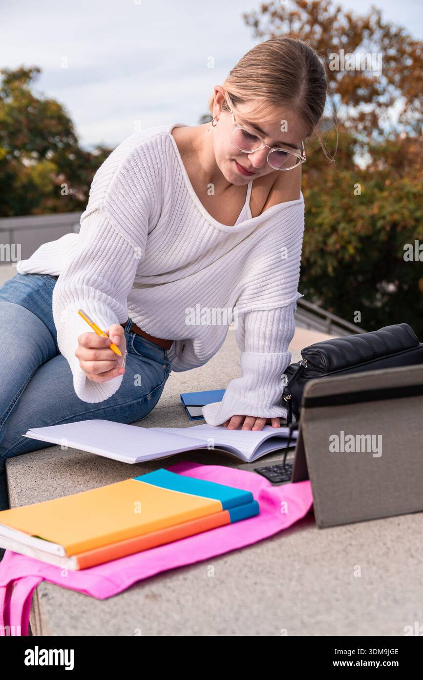 Young woman student studying outdoors on campus Stock Photo