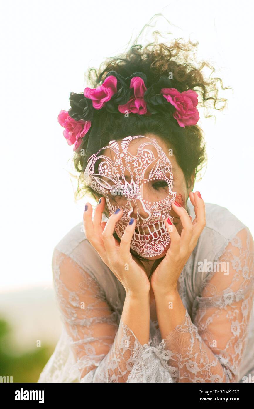 Mysterious woman wearing lace dress and skull mask celebrating carnival Stock Photo
