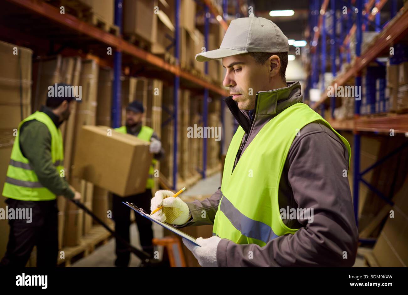 Workshop Inventory Control Warehouse inventory control with worker writing checklist as boxes are ...