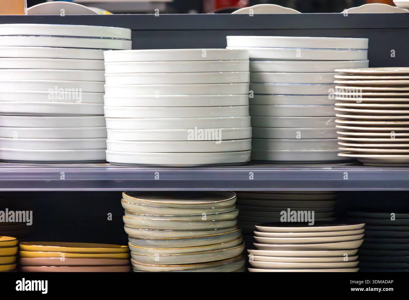 Empty ceramic plates stack inside shop interior on shelf Stock Photo