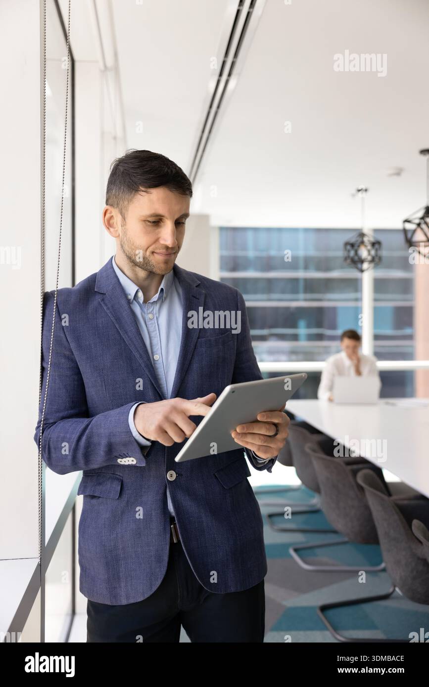 Young businessman in suit working on digital tablet device Stock Photo
