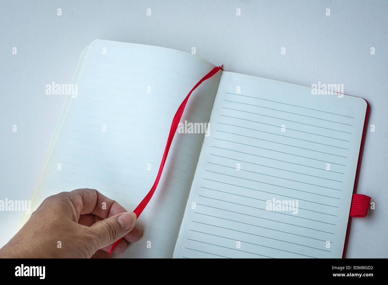 Open lined notebook with red bookmark. Isolated on white surface, top view. Space for text. Stock Photo