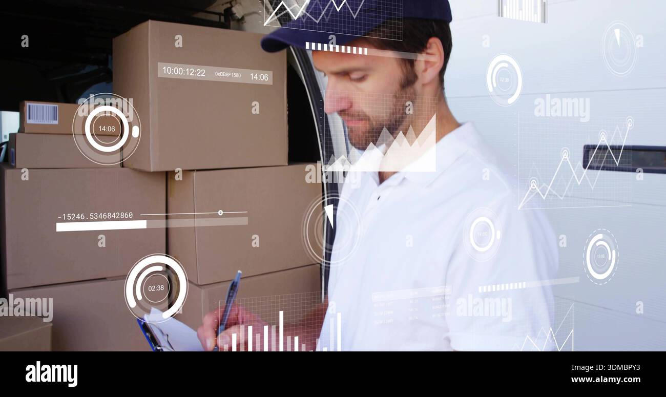Checking clipboard, man wearing navy-cap white-polo, writing with pen in van amid stacked-boxes HUD Stock Photo