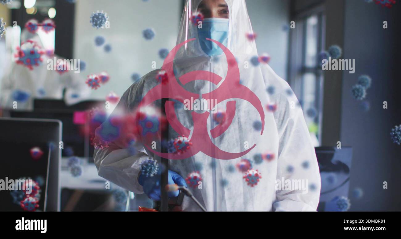 Fogging tech wearing white suit blue mask and gloves holding fogger in office with biohazard symbol Stock Photo