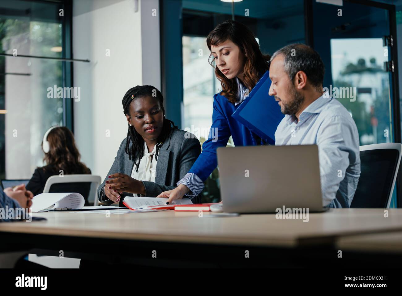 Diverse business team collaborating on project in modern office Stock Photo