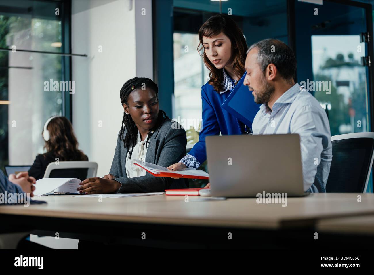 Business colleagues collaborating on project documentation in office Stock Photo