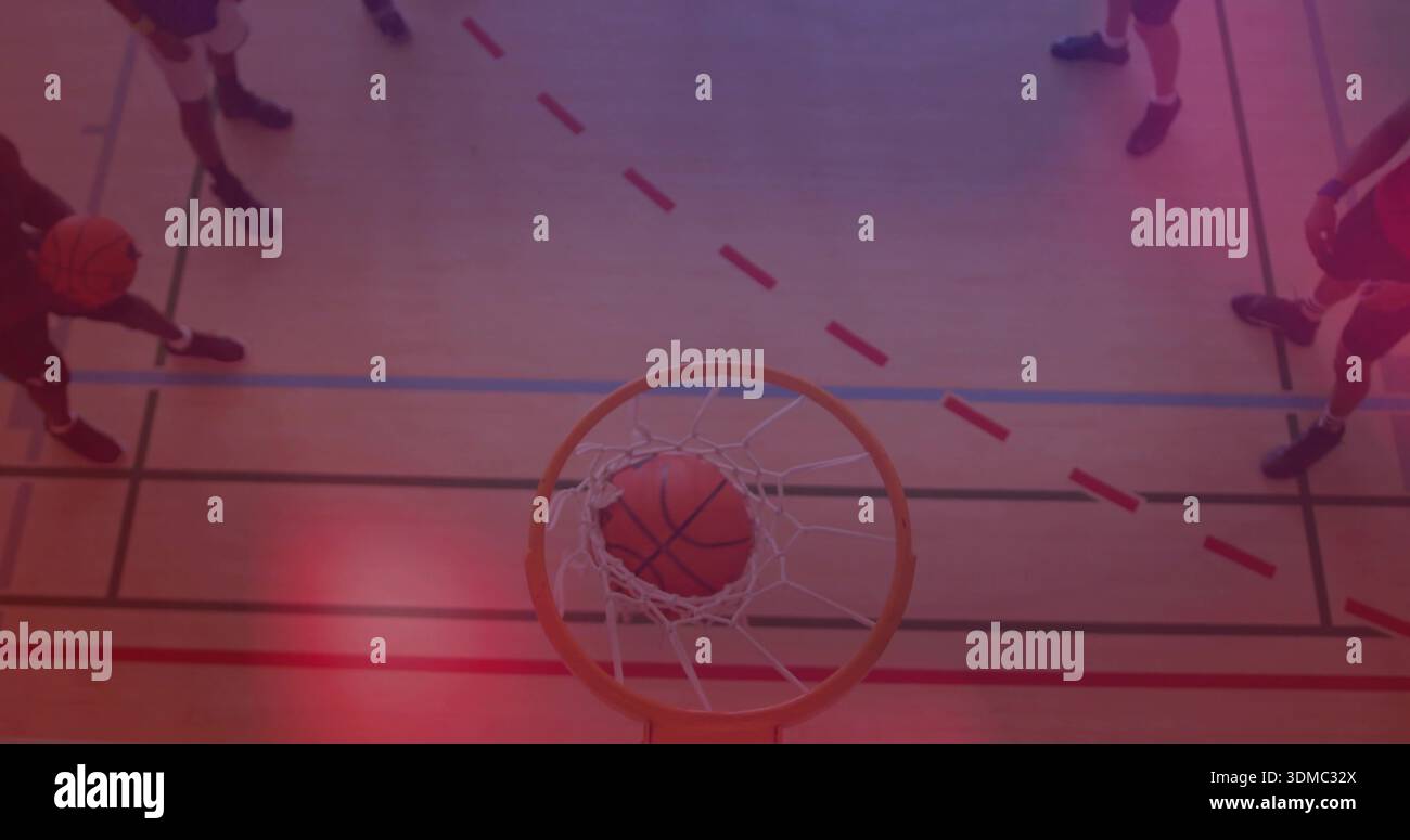 Framing overhead gymnasium showing basketball lodged in rim net over ...