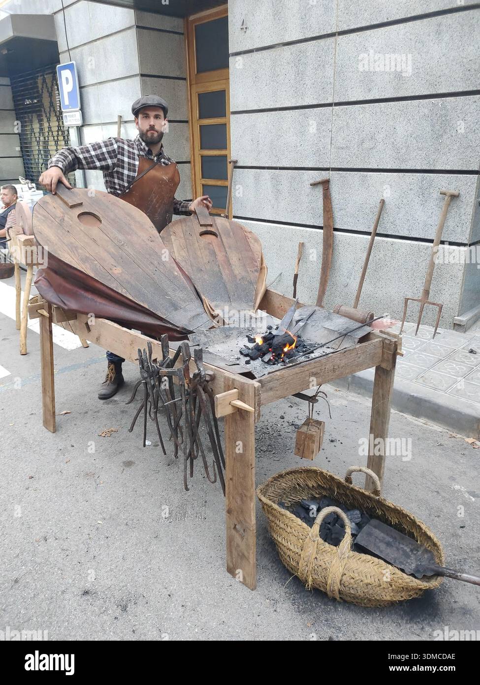 Detail of an old blacksmith working on forging tools in the street, fair of the old craftsmen's guilds. Stock Photo