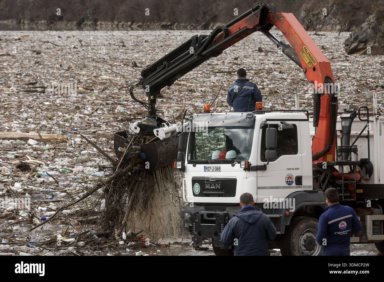 Clogging Rivers Workers use a crane to remove waste clogging the Drina river in ...