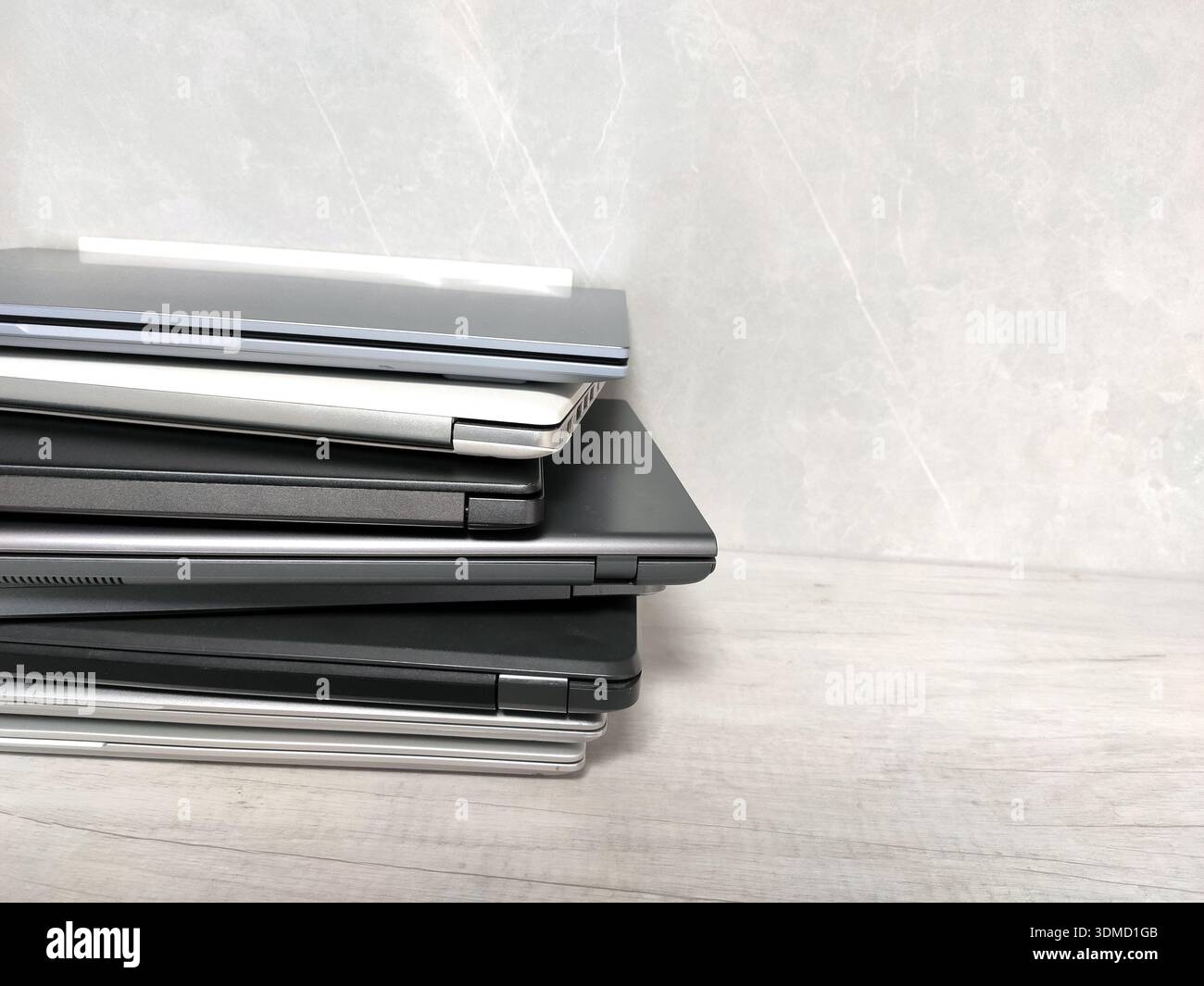 stack of pile of laptops on a gray background. many laptop computers, communications, internet, technology, equipment, tablet, netbook Stock Photo