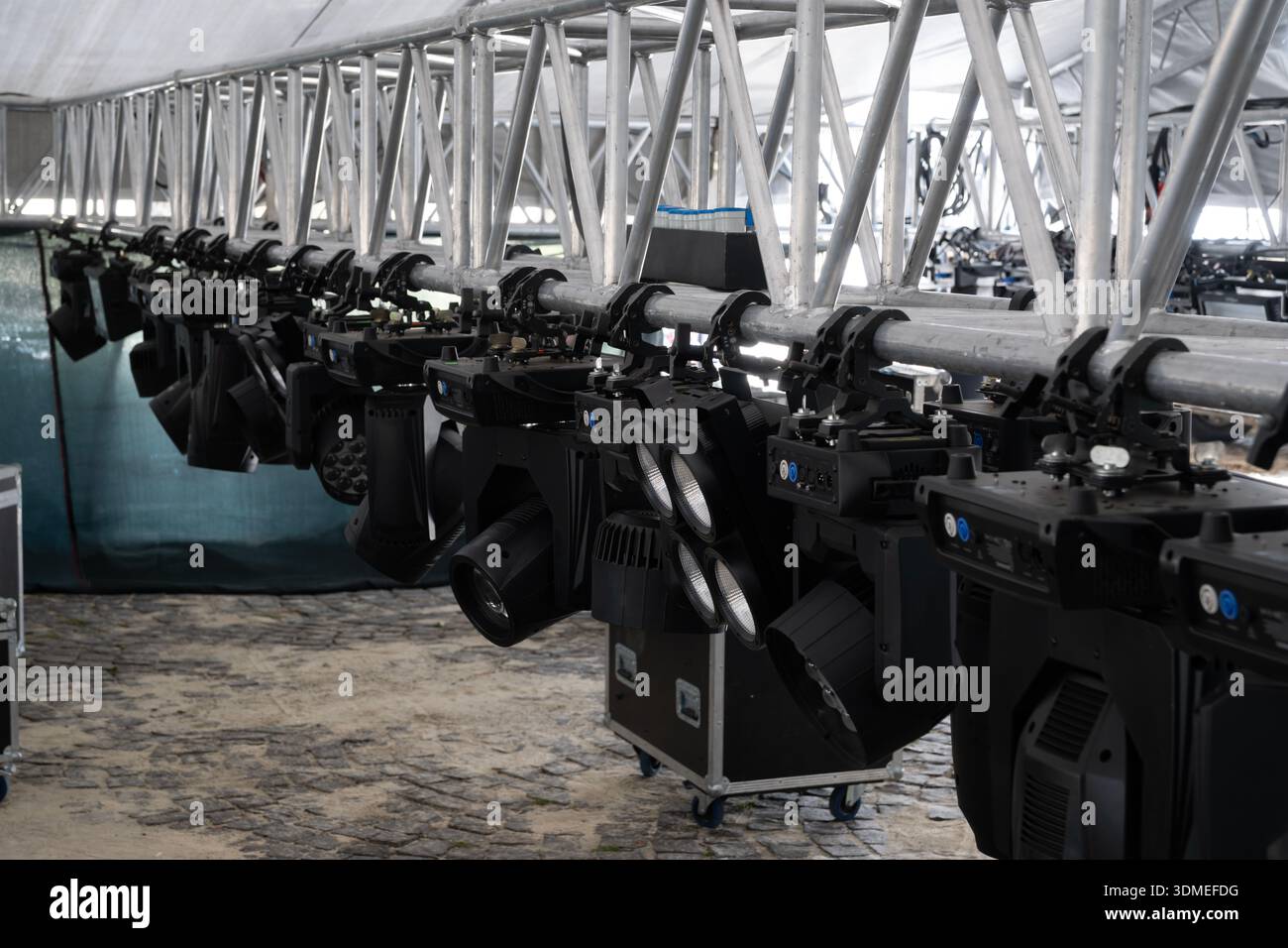 Professional stage lighting equipment setup for concerts and live events, hanging from a metal truss structure, prepared for show illumination Stock Photo